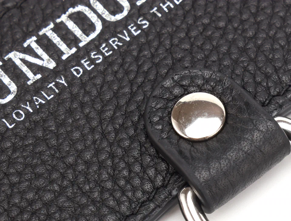 Black litchi-grain leather with the pressed UNIDOLLY wordmark